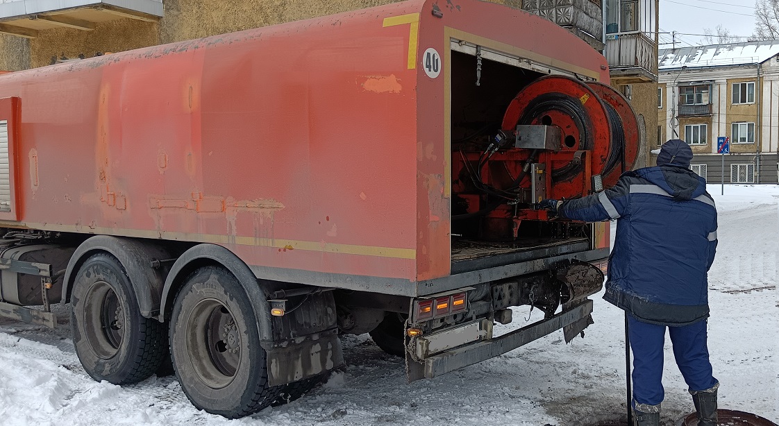 Каналопромывочная машина и работник прочищают засор в канализационной системе в Кувандыке