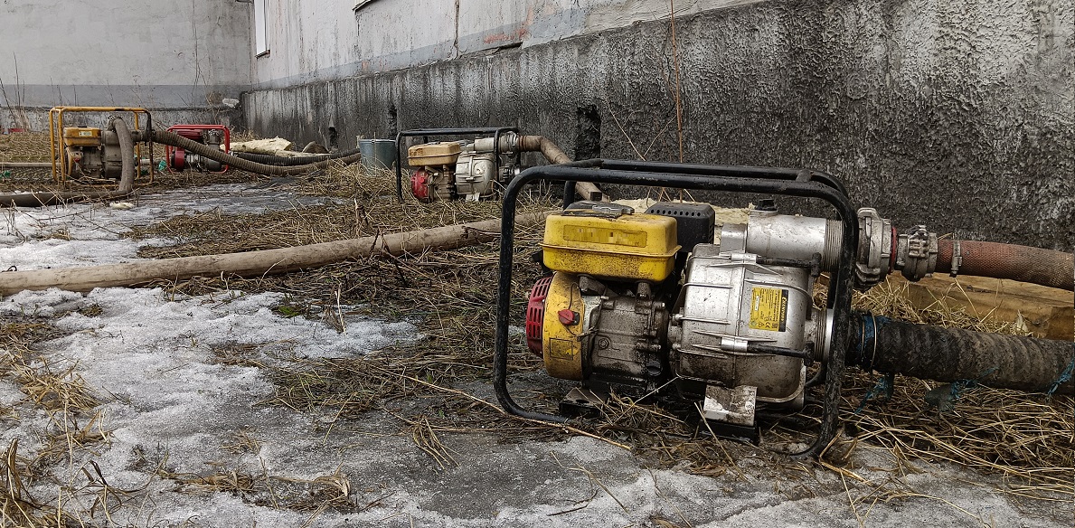 Откачка мотопомпами талой воды из подвала дома в Новотроицке
